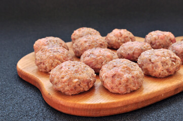Tasty Meat balls on wooden board close up, black background