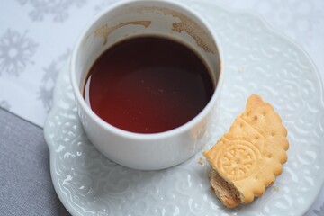 A half-empty cup of morning coffee and biscuits