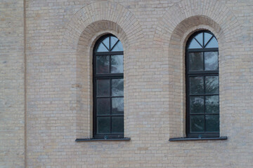 two windows in a brick building. windows in the building of the old city