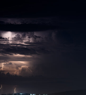 Lightning storm at night over city.