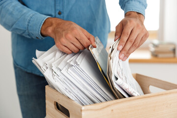 Young white man working with drawings in box at office