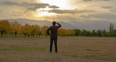 a man watching the sunset in the autumn season.
