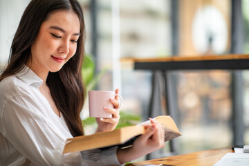 Shot of an Asian young business Female working on laptop computer in her workstation.Portrait of Business people employee freelance online report marketing e-commerce telemarketing concept.
