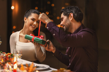 holidays, party and celebration concept - happy friends or couple having christmas dinner and...