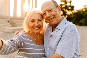 White senior couple hugging and smiling together outdoors