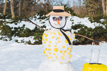 snowman with valise ready for travel to tropical country