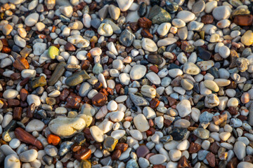 Background of wet stones on a beach surface near water 