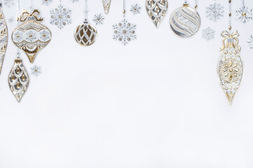 Banner. Happy New Year and Merry Christmas 2022. Snowflakes with Christmas tree toys made of gold and silver foil on a white background. Flat lay.
