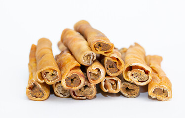 A treat for pets. Veins and skin rolled into a roll on a white background, dried bone for cleaning dogs teeth.