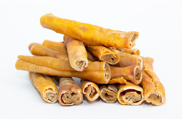 A treat for pets. Veins and skin rolled into a roll on a white background, dried bone for cleaning dogs teeth.