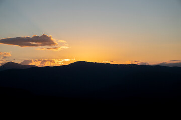Colorful morning silhouettes of coniferous forest Beautiful sunset in the mountains