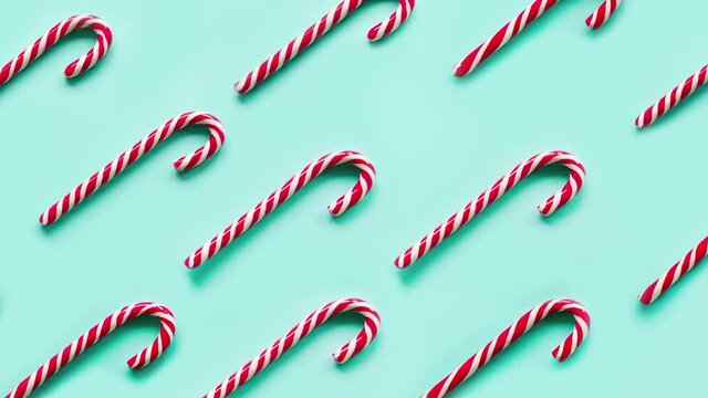 Slow motion of seamless pattern with Christmas Candy Cane on blue background. Xmas traditional festive sweets. High quality 4k footage