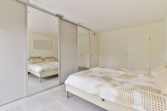 Contemporary bedroom interior with bed against the clothes closet