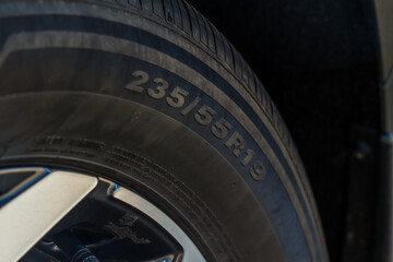 Close up view of tire with tire width, height and wheel diameter designation. Tire size types labels.