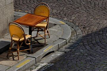 Table et chaises de bistro sur un trottoir pavé