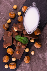 Fototapeta na wymiar Milk chocolate with hazelnuts on a slate board. Flat lay.