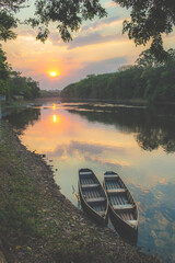 Portrait of a beautiful color sunset and two canoes in the foreground.