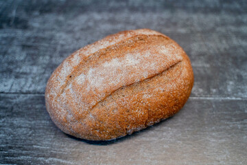 fresh appetizing rye bread on a board sprinkled with flour on a wooden table