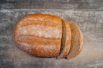 fresh appetizing rye bread on a board sprinkled with flour on a wooden table