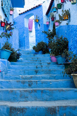 Fototapeta na wymiar Chefchaouen, Morocco - 6 October, 2021: Blue street and houses in Chefchaouen, Morocco. Beautiful colored medieval street painted in soft blue color.