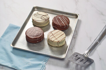 Typical Argentinean Alfajores covered with chocolate fresh from the oven. Argentinean sweets.