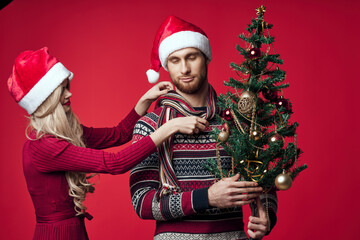 young couple christmas decorations holiday posing red background