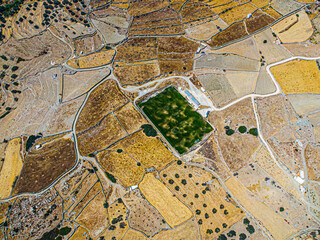 Aerial view on a green football field during drought on sifnos island, Greece