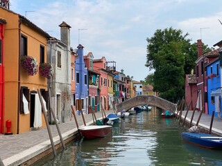 Fototapeta na wymiar Boats and colorful traditional painted houses in a canal street houses of Burano island, Venice, Italy