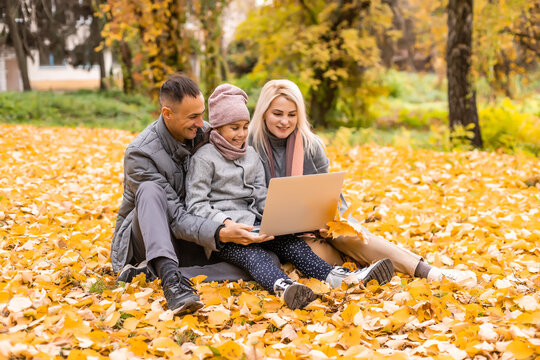 Family with laptop on an autumn day
