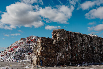 Photo of a large amount of garbage and rubbish at the dump in the street under the blue sky with...