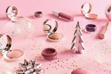Makeup products on pink background. Christmas or New Year party makeup cosmetics. Blushes,...
