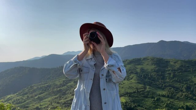 Photographer Takes a Pictures of a Mountains View on a Camera. Traveler Girl Photographs of Landscape on Sunrise.