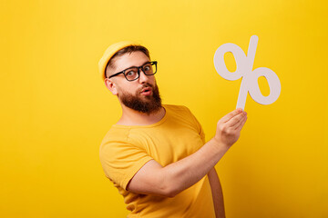 man hold percentage symbol over yellow background, black friday and big sales concept
