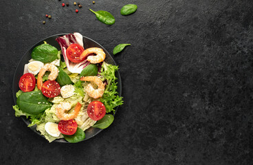 Fresh seafood salad. Grilled shrimp, fresh vegetable salad and egg. Fried shrimps. Healthy food on stone background with copy space for your text