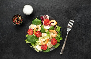 Fresh seafood salad. Grilled shrimp, fresh vegetable salad and egg. Fried shrimps. Healthy food on stone background