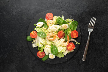 Fresh seafood salad. Grilled shrimp, fresh vegetable salad and egg. Fried shrimps. Healthy food on stone background