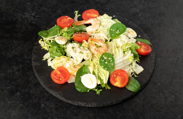 Fresh seafood salad. Grilled shrimp, fresh vegetable salad and egg. Fried shrimps. Healthy food on stone background
