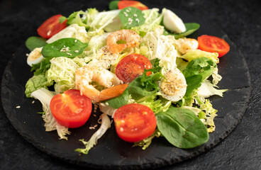 Fresh seafood salad. Grilled shrimp, fresh vegetable salad and egg. Fried shrimps. Healthy food on stone background