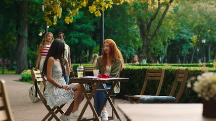 Multiethnic two ladies and other two came for a meeting at the cafe they hugging with each other and enjoy the time