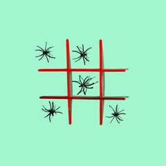 A tic tac toe game with orange lines and black spiders on pastel green background. Scary Hallooween...