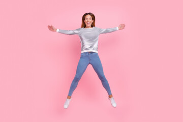 Photo of sweet adorable young woman dressed striped pullover jumping high like star isolated pink color background