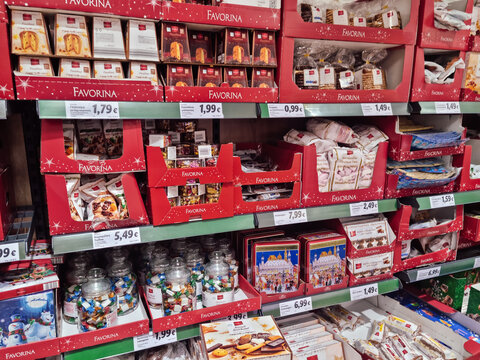 Christmas supermarket sweets on shelf. Festive desserts like cakes, German Stollen fruit bread, lebkuchen and marshmallows on a Lidl supermarket display.