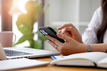 Fototapeta premium Close up view of a young Asian woman using a blank screen smartphone