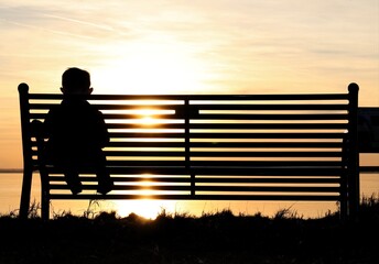 silhouette of a person sitting on a bench