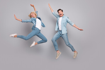Fototapeta na wymiar Photo of energetic sporty lover couple jump enjoy flight wear casual jeans outfit isolated grey color background