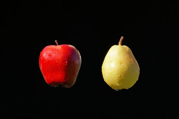 Apfel und Birne auf schwarz mit Wassertropfen