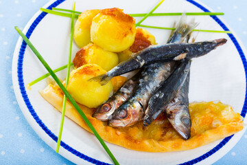 Roasted anchovies with garnish of potato croquettes, flatbread and greens