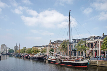 Fototapeta na wymiar Leeuwarden, The Netherlands, October 10, 2021: Zuiderstadsgracht canal, lined with historic boats as well as houses, one of them the birthplace of Mata Hari