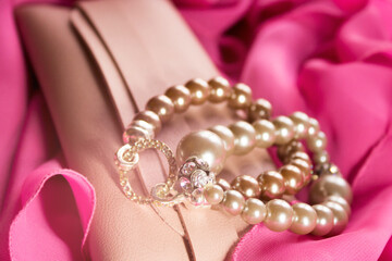 Bracelets and a beige clutch on a pink dress