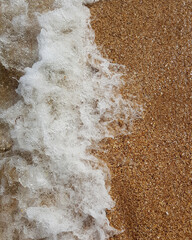 Active waves surf with sand close up